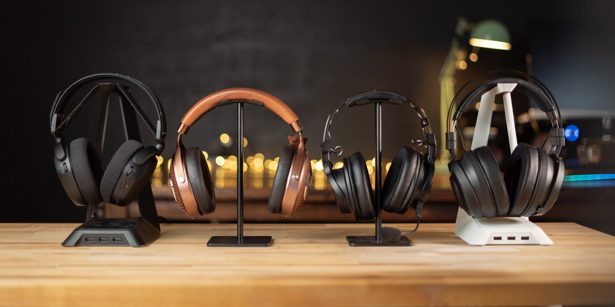 Four headphone stands with headsets on them